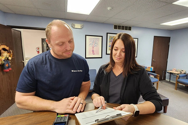 Staff Member Checking Patient In To Office