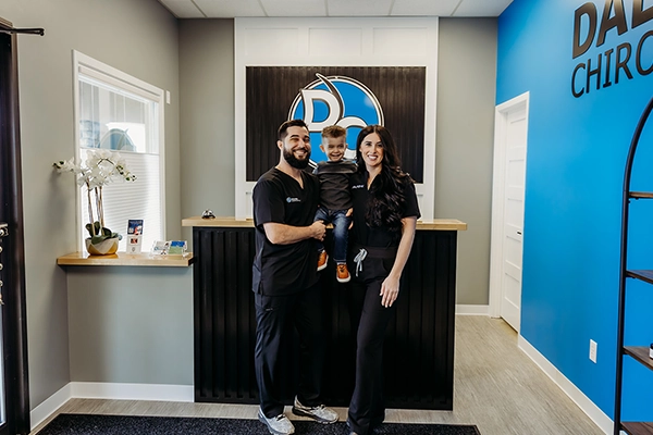 Chiropractor Alexander Dalton With Staff And Smiling Patient
