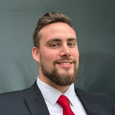 Chiropractor Christopher Stevenson Smiling In Front Of Green Background