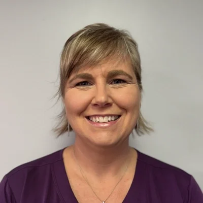 Jillian Gay smiling in a purple shirt.